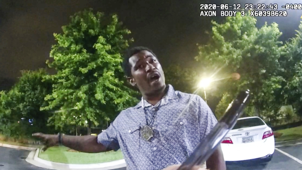 This screen grab taken from body camera video provided by the Atlanta Police Department shows Rayshard Brooks speaking with Officer Garrett Rolfe as Rolfe writes notes during a field sobriety test in