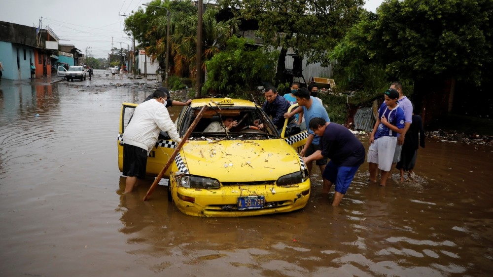 Neighbors try to move a taxi dragged by the water during floods caused by Tropical Storm Amanda at El Modelo neighborhood, in San Salvador, El Salvador May 31, 2020. REUTERS/Jose Cabezas