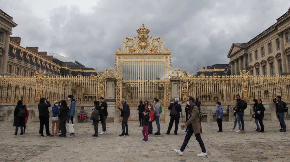 People lining up along the Gate of Honor to visit the Chateau de Versailles, west Paris, Sunday, June 7, 2020. The Chateau de Versailles was reopened on June 6, after Covid-19 closure. (AP Photo/Miche