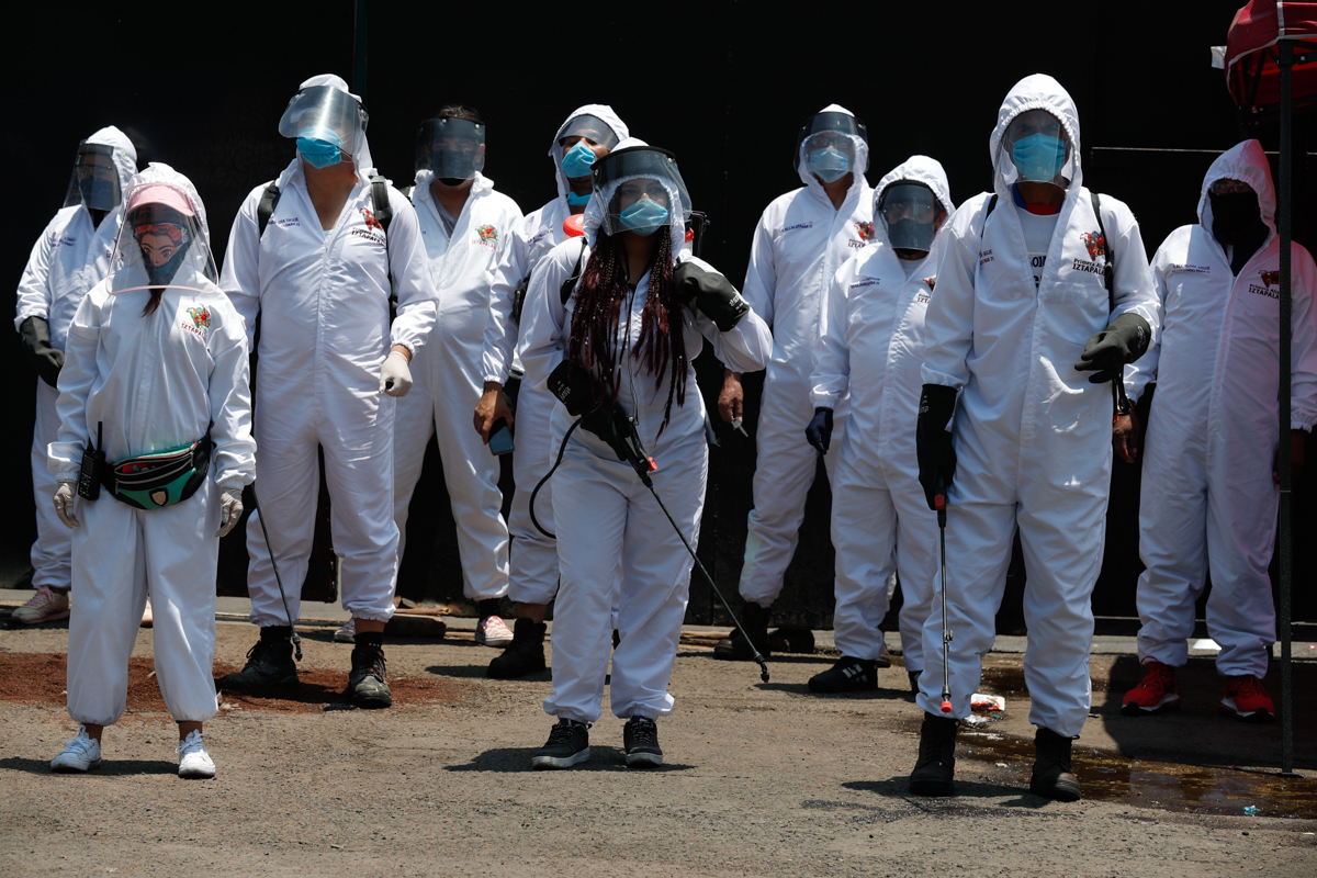 Cemetery workers in protective gear pose for a group photo as they work at the San Lorenzo Tezonco Iztapalapa cemetery in the Iztapalapa neighborhood of Mexico City, Tuesday, June 2, 2020. The cemeter