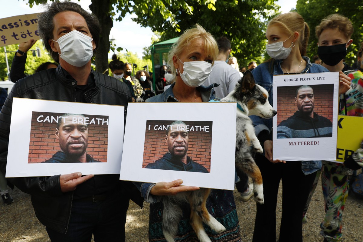 epa08454492 Protesters of the Afroamerican Black lives matters movement hold placards and banners to protest against the Police brutality in USA in memory of George Floyd in front of the US embassy in