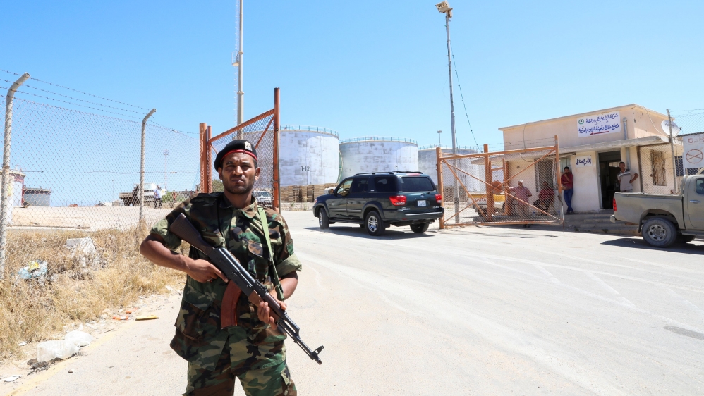 A member of the Petroleum Facilities Guard is seen at the entrance of Azzawiyah Oil Refinery, in Zawiyah