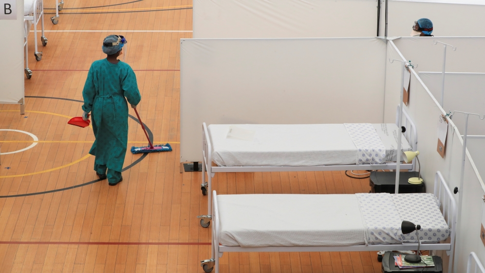 A health worker walks between beds at a temporary field hospital set up by Medecins Sans Frontieres (MSF) during the coronavirus disease (COVID-19) outbreak in Khayelitsha township near Cape Town