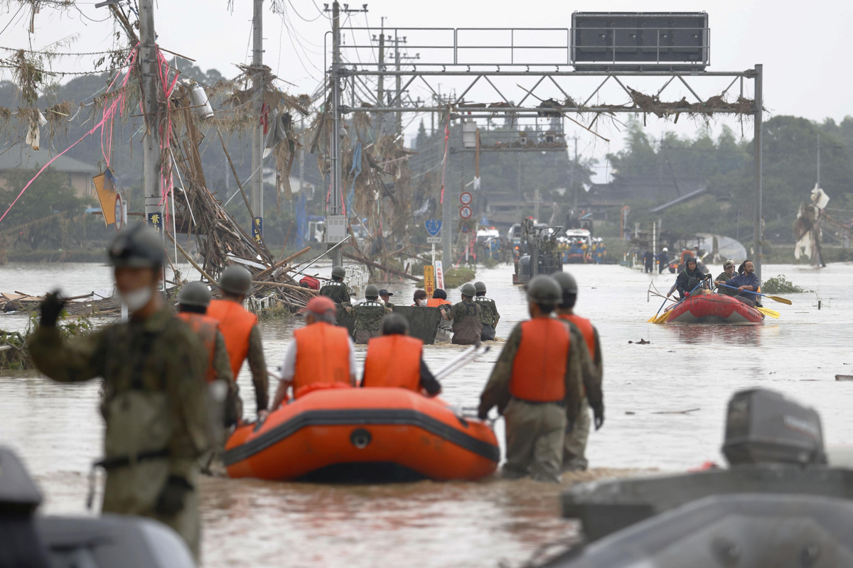Local residents are rescued by Japanese Self-Defence Force soldiers using a boat at a flooding area caused by a heavy rain in Kuma village, Kumamoto prefecture, southern Japan, in this photo taken by