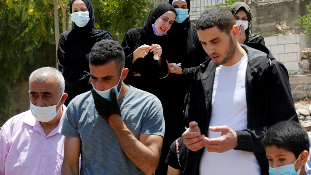 Palestinians bury a man who has died after contracting COVID-19
