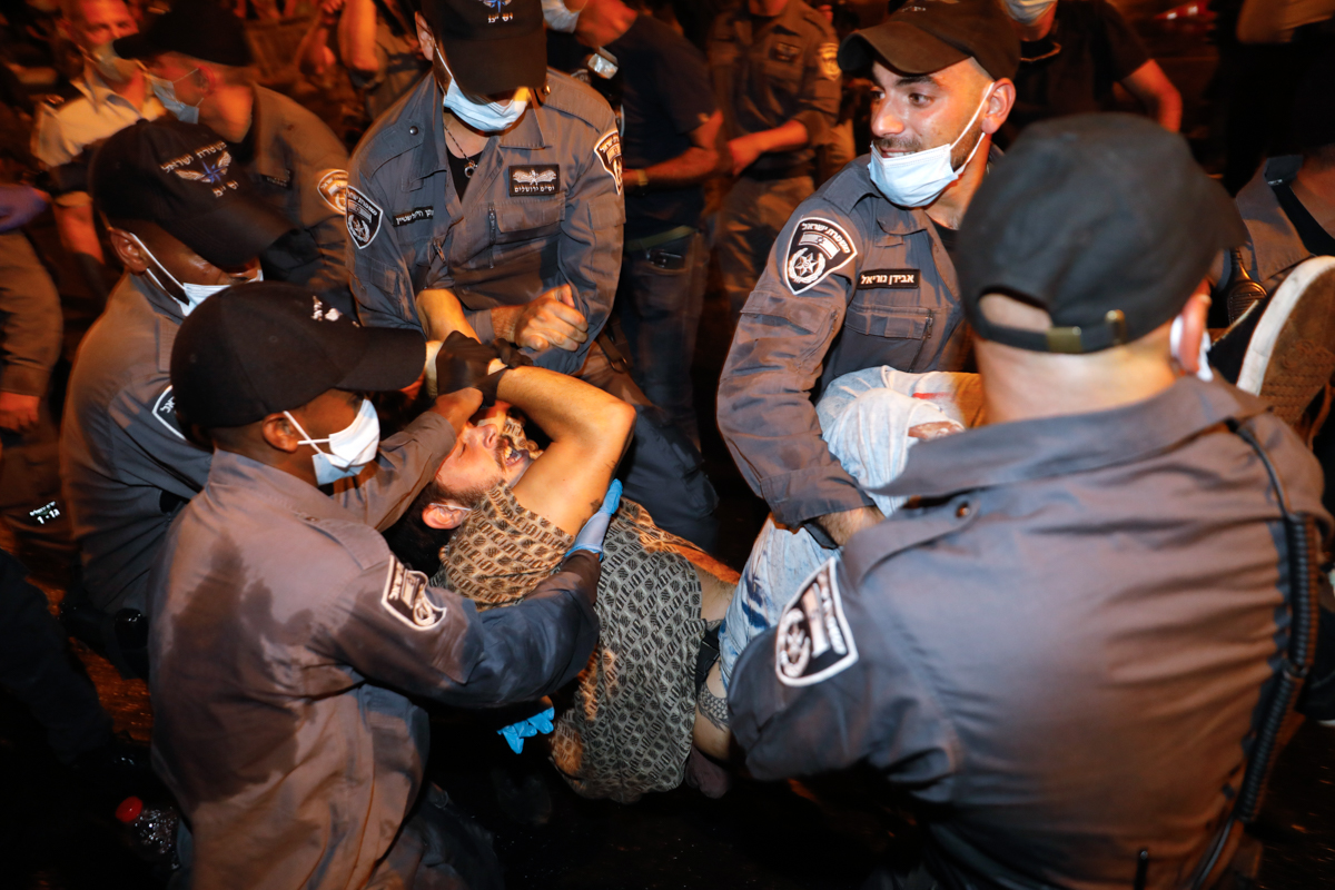 A protester is detained by Israeli police during a demonstration against Israeli Prime Minister Benjamin Netanyahu outside his official residence in Jerusalem, on July 14, 2020. - Netanyahu, 70, was i