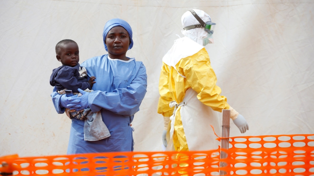 FILE PHOTO: Mwamini Kahindo, an Ebola survivor working as a caregiver to babies who are confirmed Ebola cases, holds an infant outside the red zone at the Ebola treatment centre in Butembo