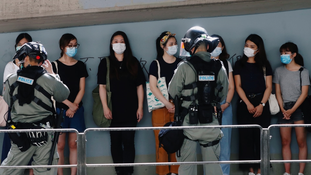 Riot police stop and search people during a march at the anniversary of Hong Kong''s handover to China from Britain in Hong Kong
