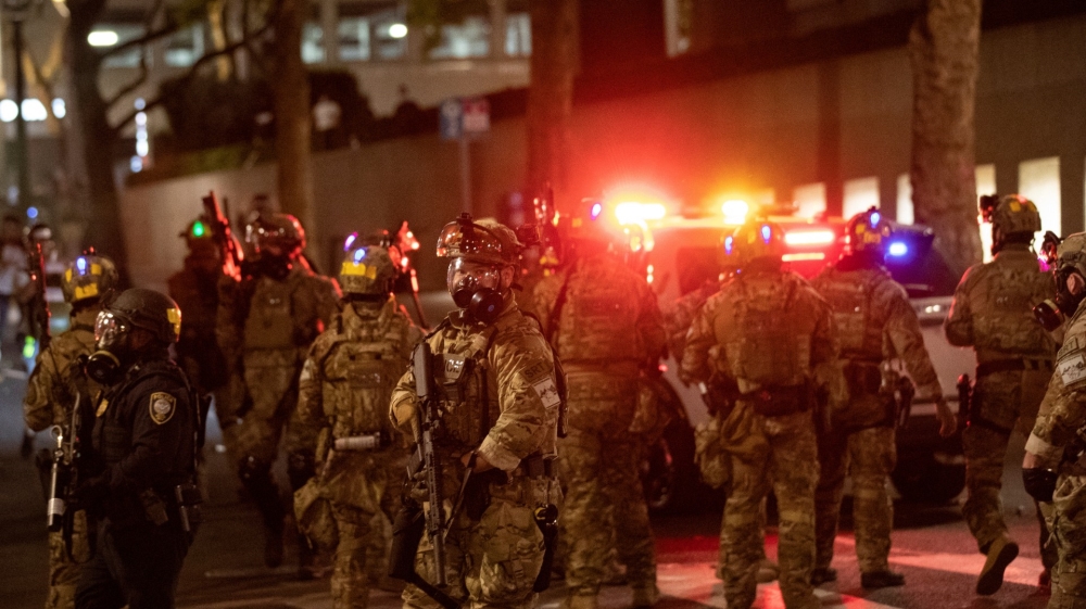 Federal law enforcement officers deployed under the Trump administration's executive order face off with protesters