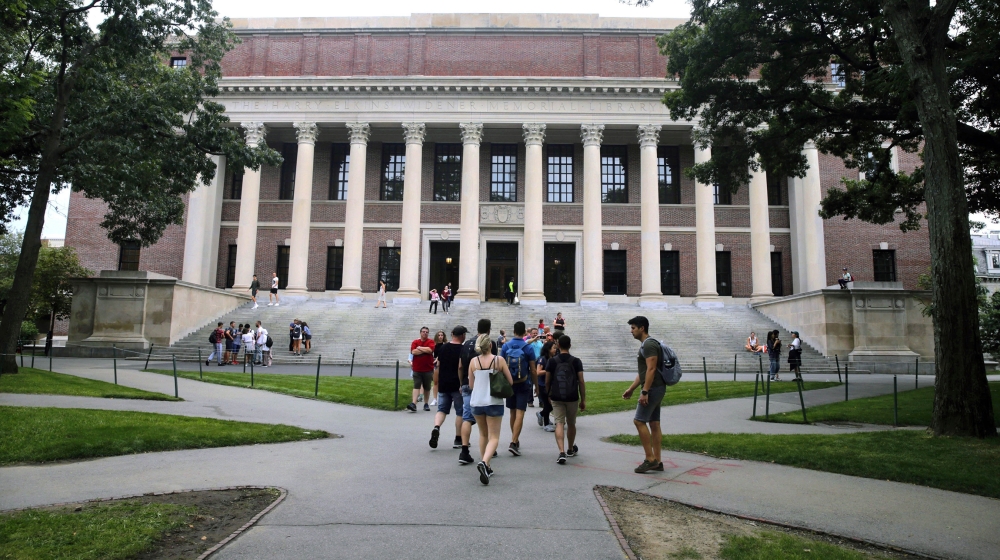 In this Aug. 13, 2019 file photo, students walk near the Widener Library in Harvard Yard at Harvard University in Cambridge, Mass. The Ivy League school announced Monday, July 6, 2020, that as the cor