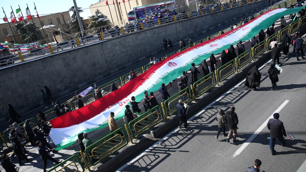 Iranians carry the Iranian flag as they gahter during the commemoration of the 41st anniversary of the Islamic revolution in Tehran