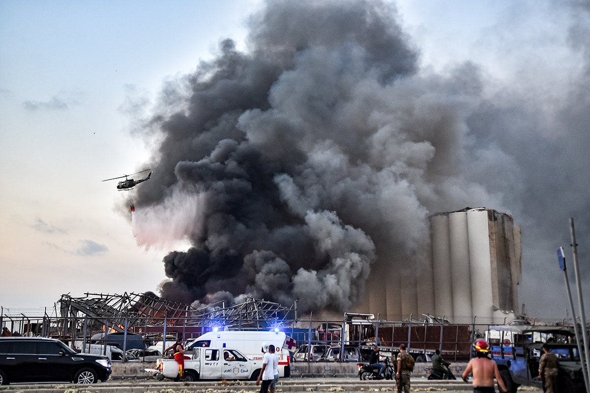 A helicopter puts out a fire at the scene of an explosion at the port of Lebanon''s capital Beirut on August 4, 2020. STR / AFP
