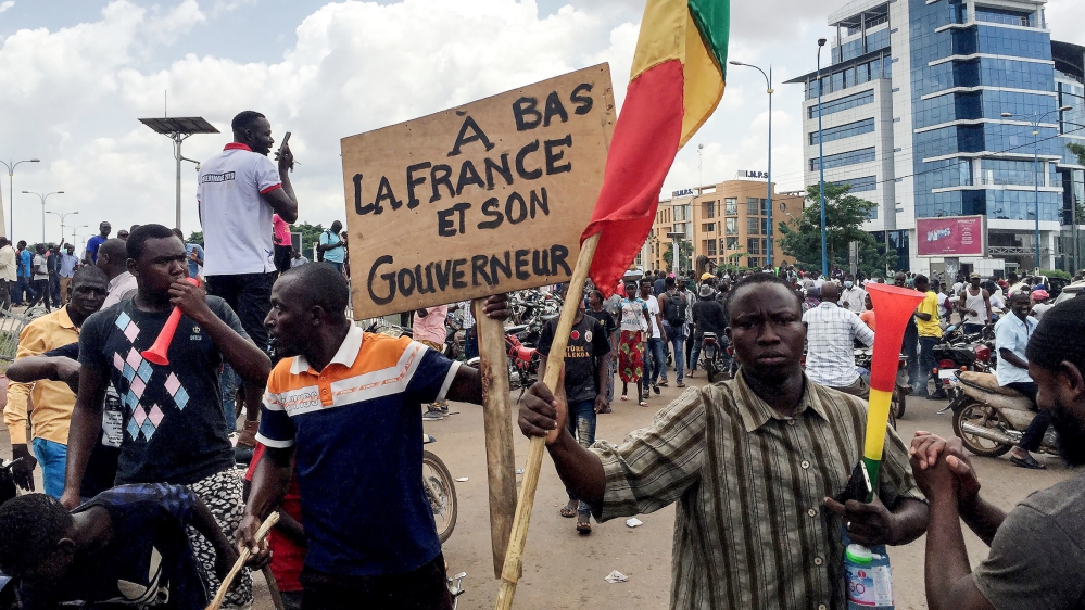 Opposition supporters react to the news of a possible mutiny of soldiers in the military base in Kati, outside the capital Bamako, at Independence Square in Bamako, Mali August 18, 2020. The sign read