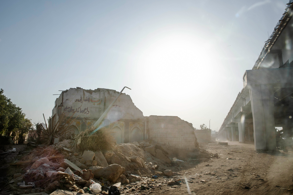 A demolished building sits below a new highway flyover under construction through the Southern Cemetery, part of the City of the Dead, a UNESCO World Heritage Site, in Cairo, Egypt, Tuesday, July 21,