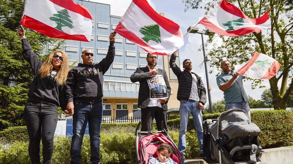 Supporters of former Prime Minister Rafiq Hariri wave Lebanese flags outside the Lebanon Tribunal on August 18, 2020 in The Hague, Netherlands. The Special Tribunal for Lebanon must render its verdict