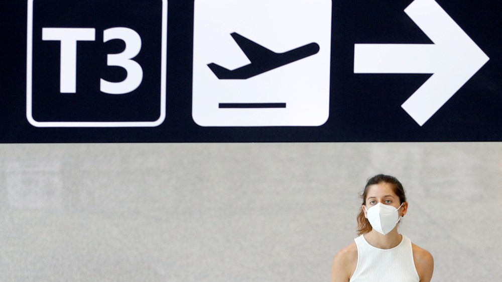 A passenger wearing a protective face mask walks at Fiumicino Airport, one of the two airports in the world to obtain the 'Biosafety Trust certification' for the correct application o