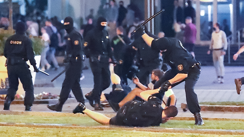epa08594451 A riot police officer hits a demonstrator during a protest after polling stations closed in the presidential elections, in Minsk, Belarus, 09 August 2020. Five candidates are contesting fo