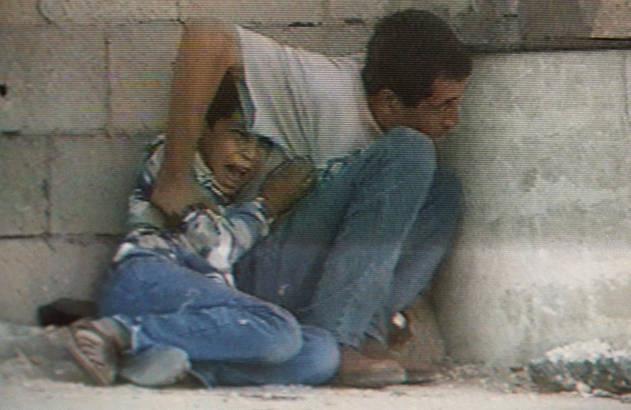 Footage taken by Talal Abu Rahma shows Jamal al-Durrah trying to protect his son, Muhammad, on September 30, 2000 in Gaza [Photo by France 2/AFP]