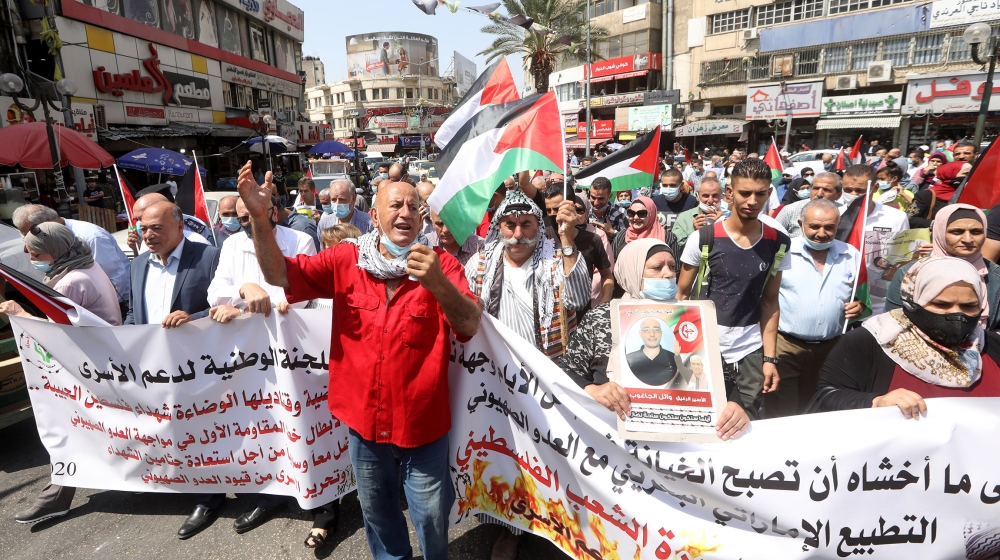 Palestinians wave Palestine flags and shout slogans during a protest against the peace agreement to establish diplomatic ties between Israel and the United Arab Emirates, in the West Bank city of Nabl