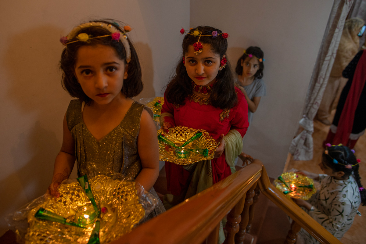 Relatives of Kashmiri bride carry henna and candles inside a decorative basket during henna ceremony of a wedding on the outskirts of Srinagar, Indian controlled Kashmir, Tuesday, Sept. 16, 2020. The