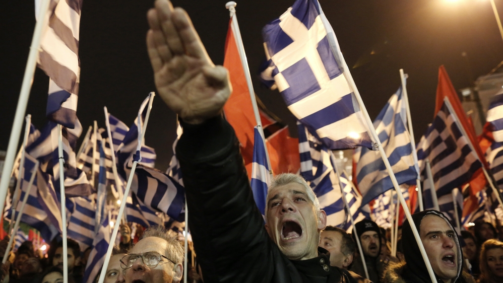 A Golden Dawn supporter raises his hand in a Nazi-style salute during a rally in Athens in 2014 [Yannis Kolesidis/AP]