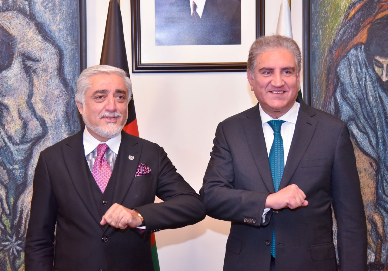 Pakistan's Foreign Minister Shah Mahmood Qureshi, right, bumps elbows with the head of Afghanistan's peace council, Abdullah Abdullah, in Islamabad [MoFA handout via Reuters]