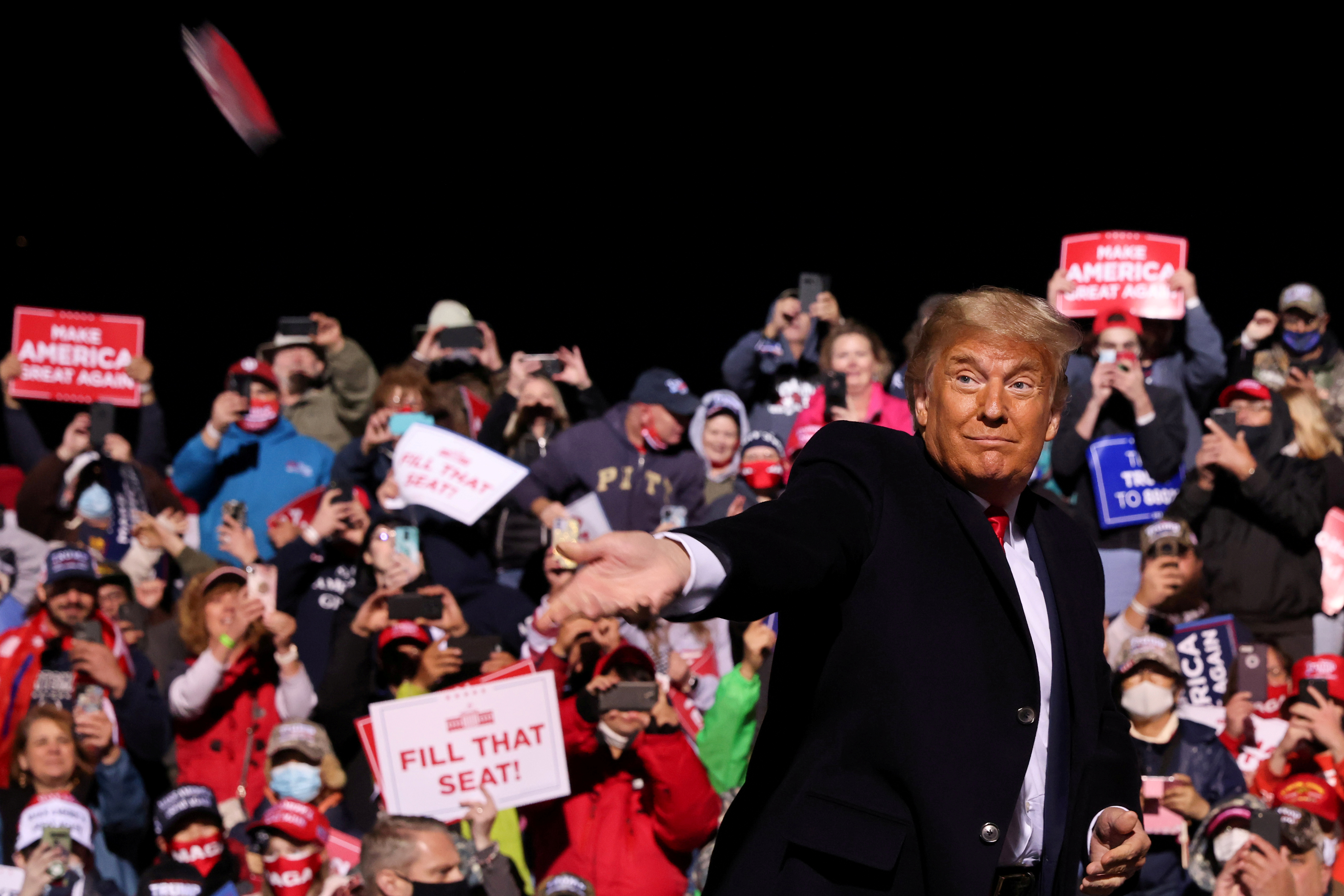 President Donald Trump throws face masks to the crowd as he arrives to hold a campaign rally at John Murtha Johnstown-Cambria County Airport in Johnstown, Pennsylvania [Jonathan Ernst/Reuters]