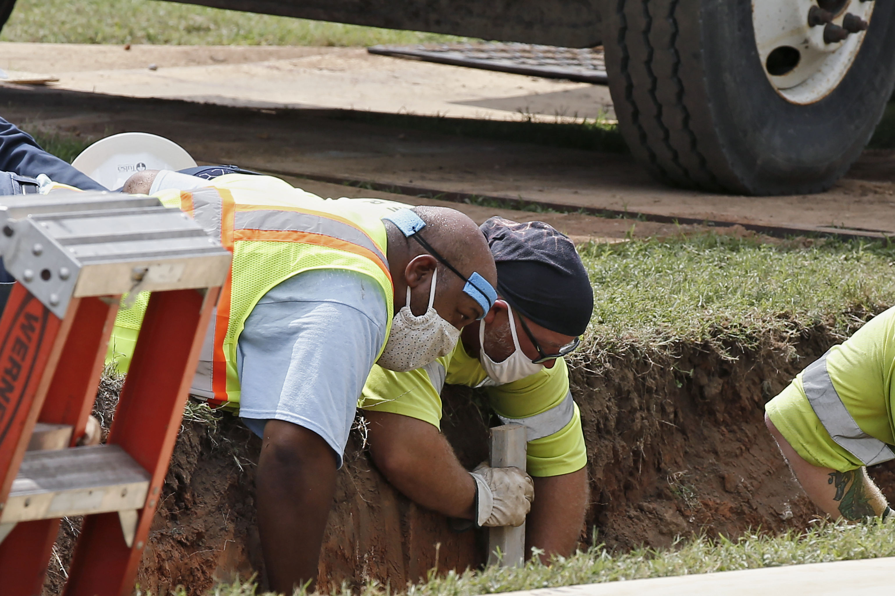 Workers reinforce the sides of an excavation site