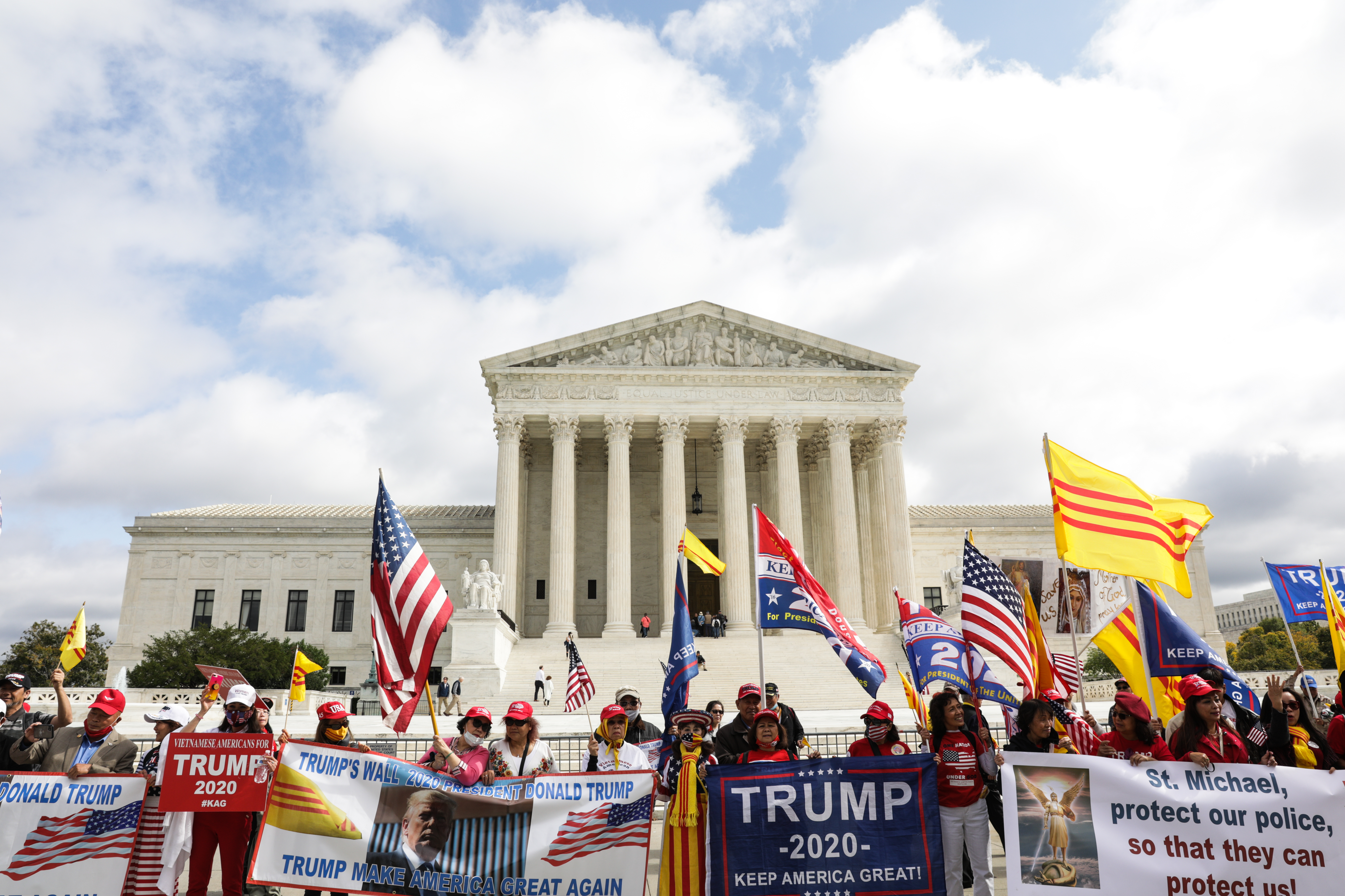 Vietnamese-American Trump supporters, who travelled across the United States in multiple caravans to Washington, DC, gather in front of the Supreme Court, waving US and South Vietnamese flags during the confirmation hearing of Justice Amy Coney Barrett on October 13, 2020 [Valerie Plesch/Al Jazeera]