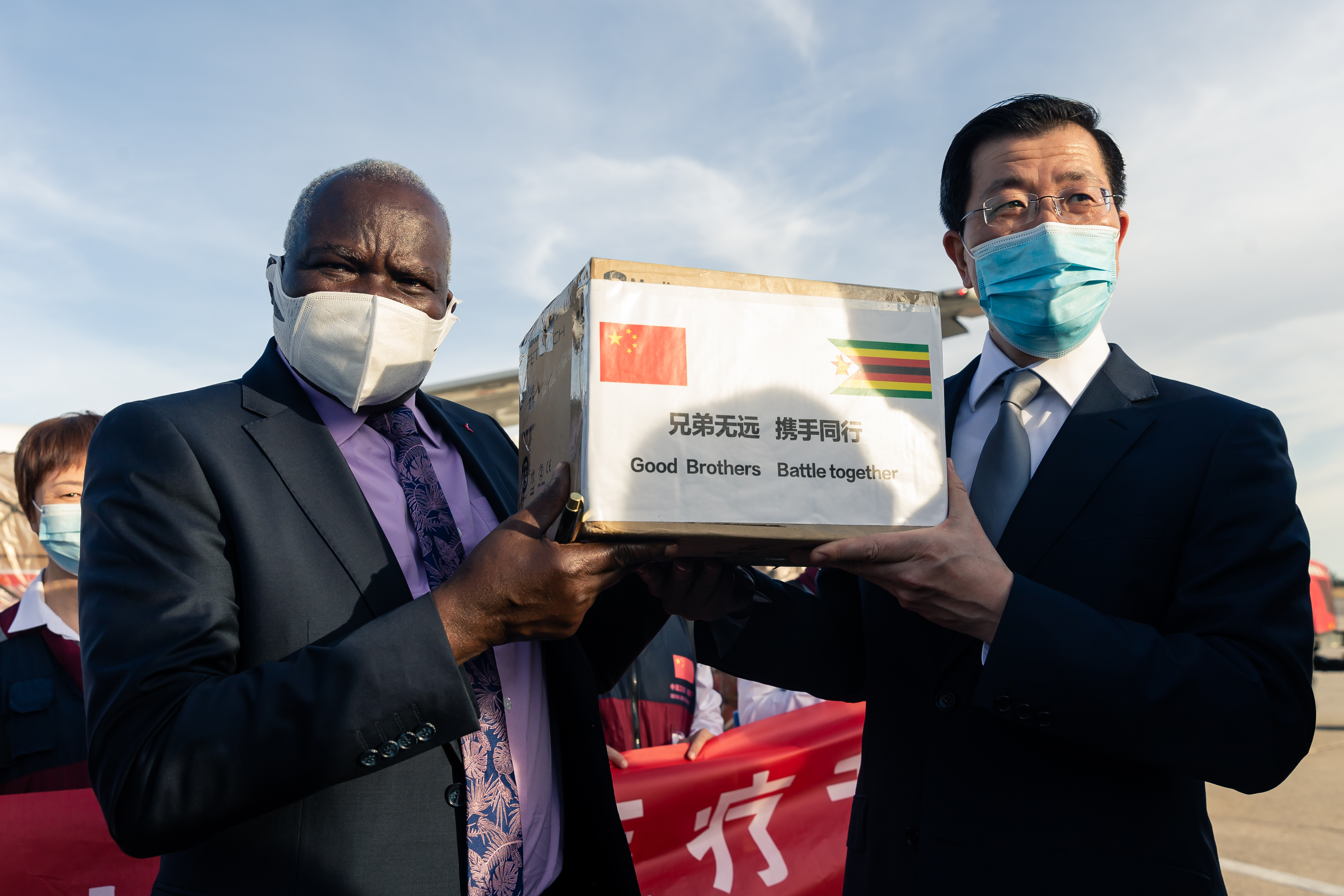 Zimbabwe Minister of Local Government and Social Welfare July Moyo receives a box of medical equipment from Chinese ambassador Guo Shaochun on May 11, 2020, at a ceremony at the Robert Mugabe International Airport in Harare [File: AFP/Jekesai Njikizana]