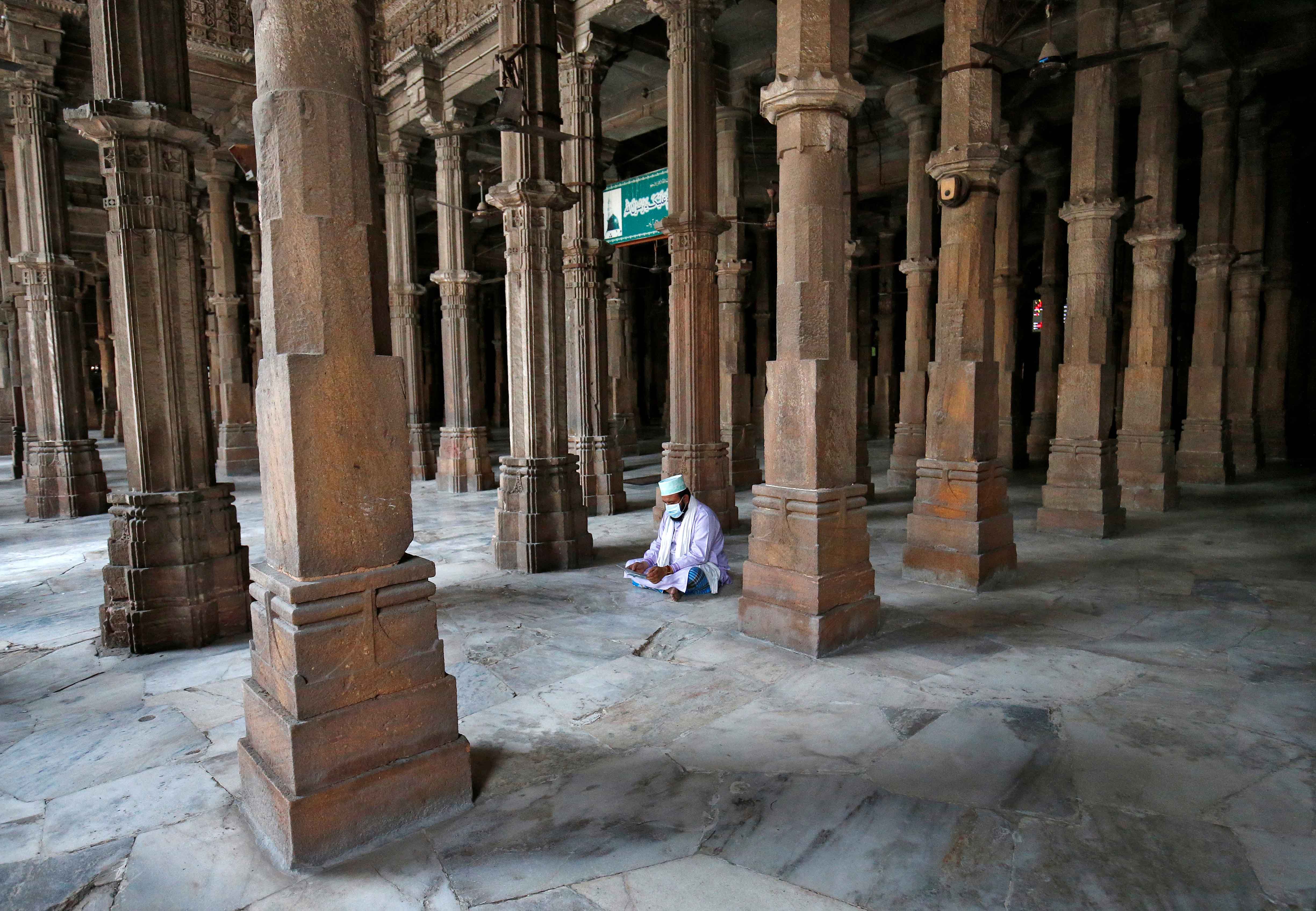 A Muslim reads the Quran in Juma Masjid on the first day of Ramadan in Ahmedabad, India on April 25, 2020 [File: Reuters/Amit Dave]
