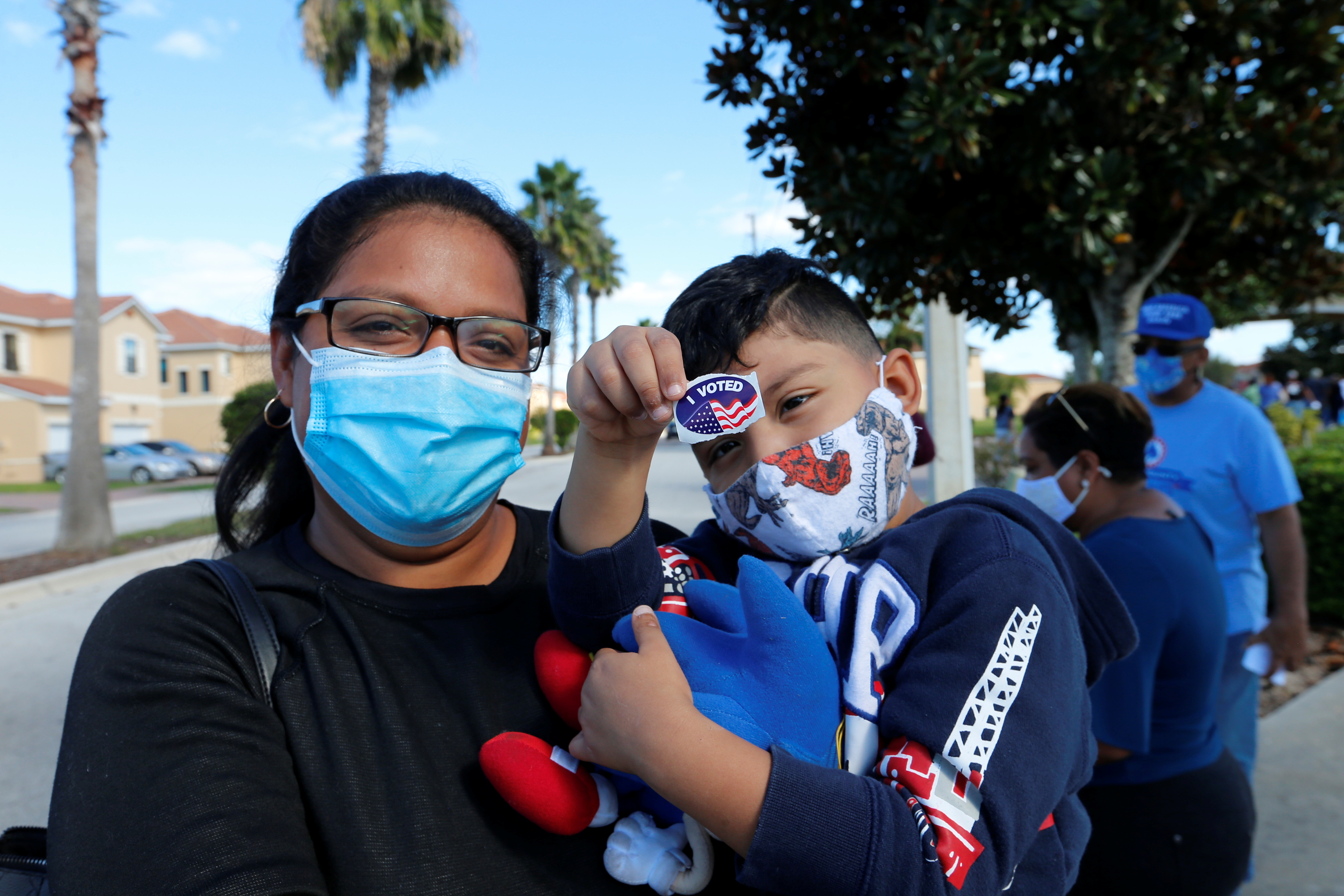 Hazel Martinez holds 4-year-old Leonardo Perez after she voted on Election Day in Poinciana, Florida. [Joe Skipper/Reuters]
