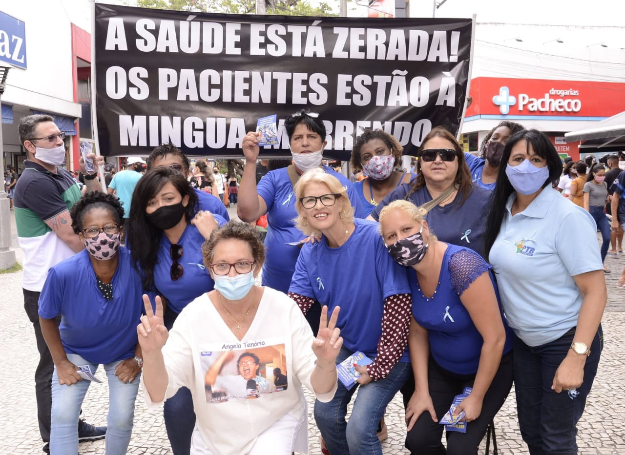 Dr Angela Tenório, front, who is running for city councillor in Rio de Janeiro, stands with supporters and a poster that reads, 'Healthcare has been gutted, patients are perishing, dying' [Photo by Daniel Lewinsonh, courtesy of Angela Tenório]
