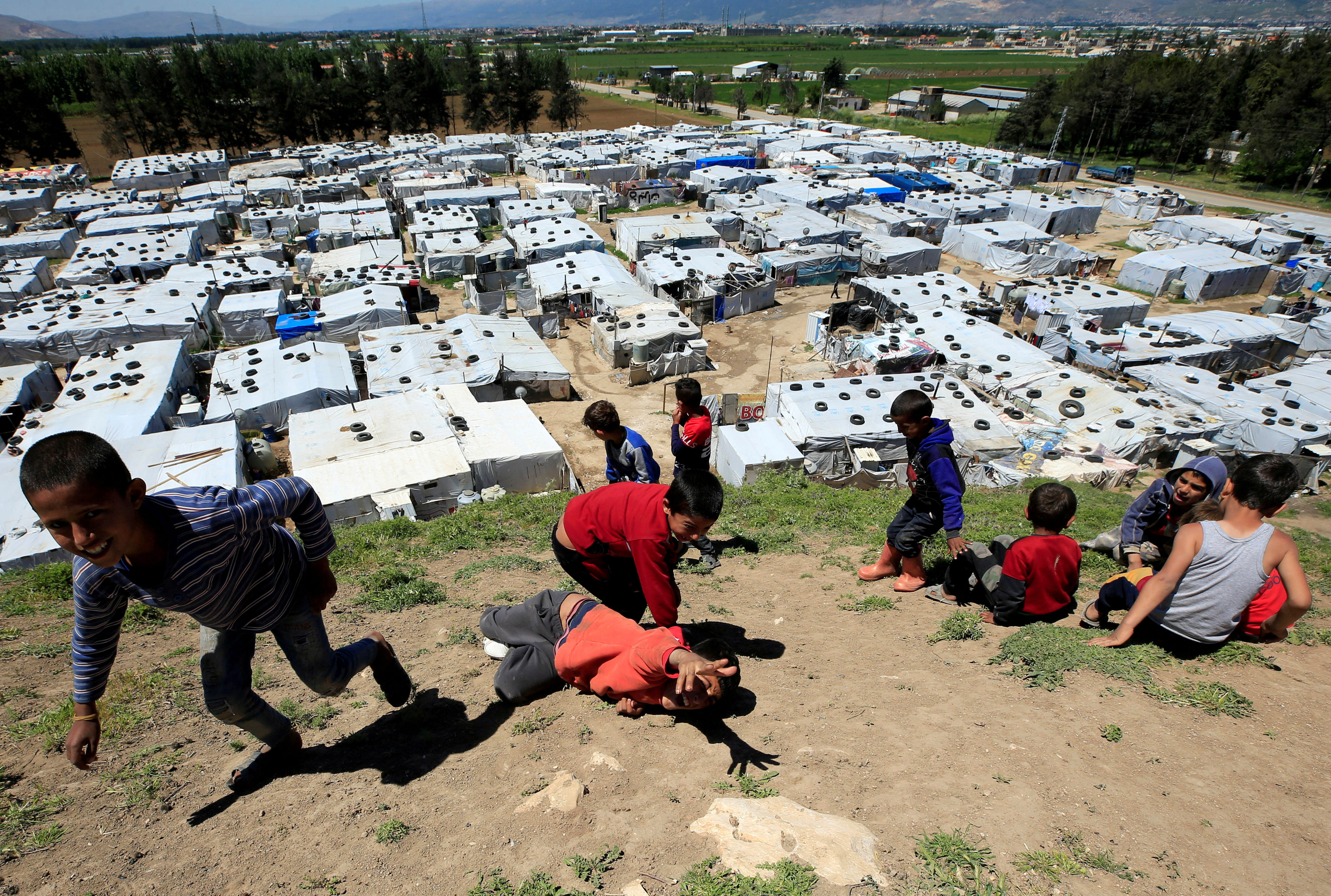 Syrian refugee children play together at a Syrian refugee camp in the Bekaa valley, Lebanon in 2020 [File: Ali Hashisho/Reuters]