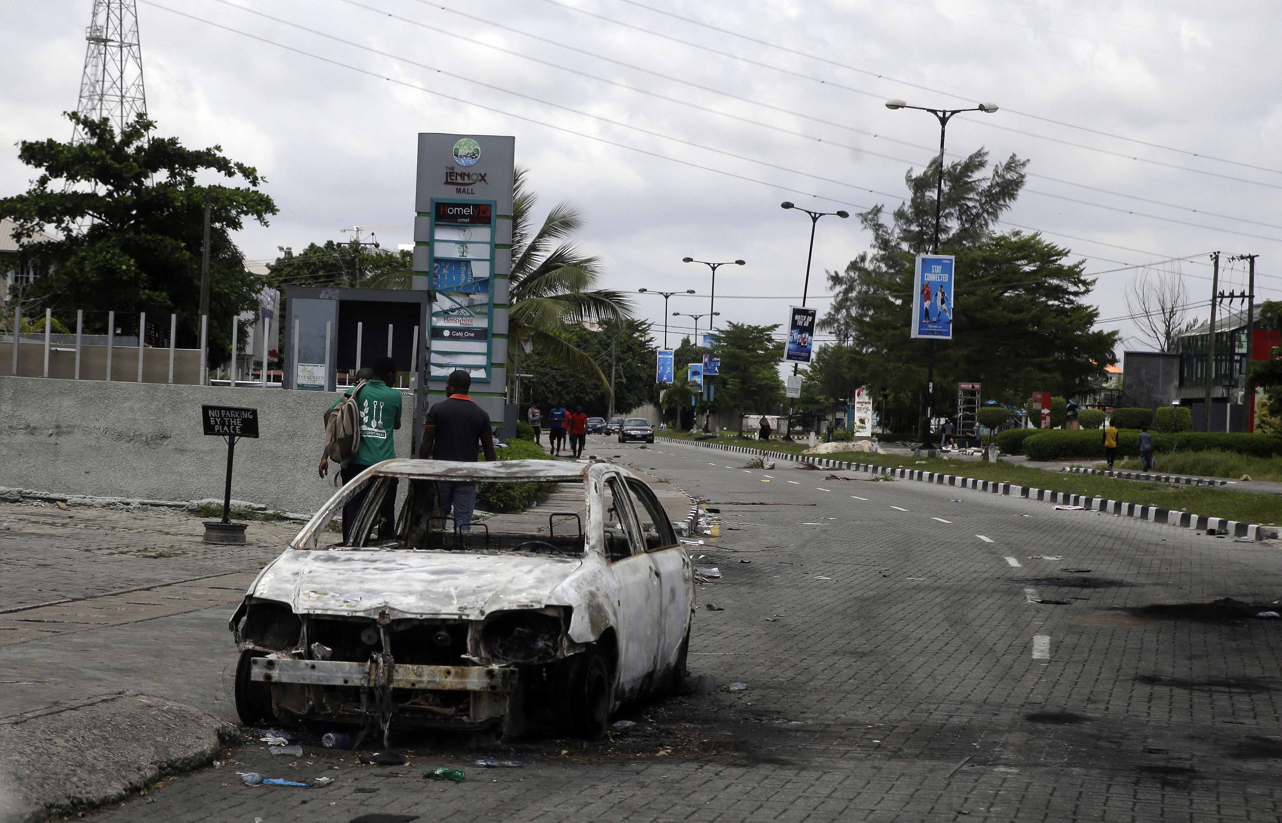 A burnt-out car is seen on Lekki Road in Lagos on October 23, 2020 [File: Sunday Alamba/AP]