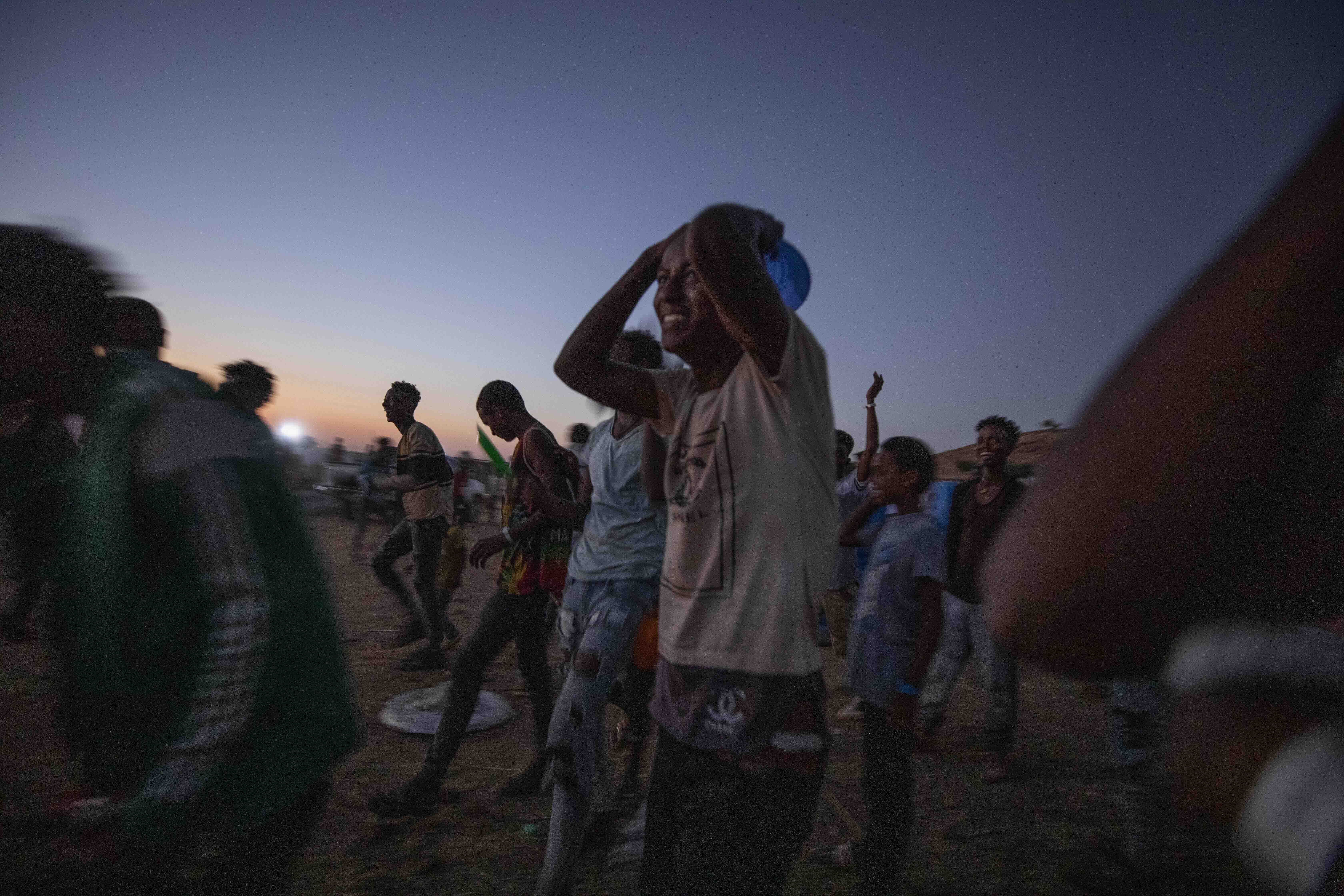 Tigray men who fled the conflict in Ethiopia's Tigray region, run to receive cooked rice from charity organisation Muslim Aid, at Umm Rakouba refugee camp in Gadarif, eastern Sudan on November 27, 2020 [File: Nariman el-Mofty/AP Photo]