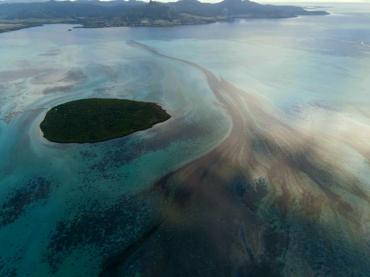 Oil leaks from the Japanese-owned MV Wakashio, a bulk carrier ship that recently ran aground off the southeast coast of Mauritius on August 10, 2020 [File: Nik Cole/Mauritian Wildlife Foundation via AP]