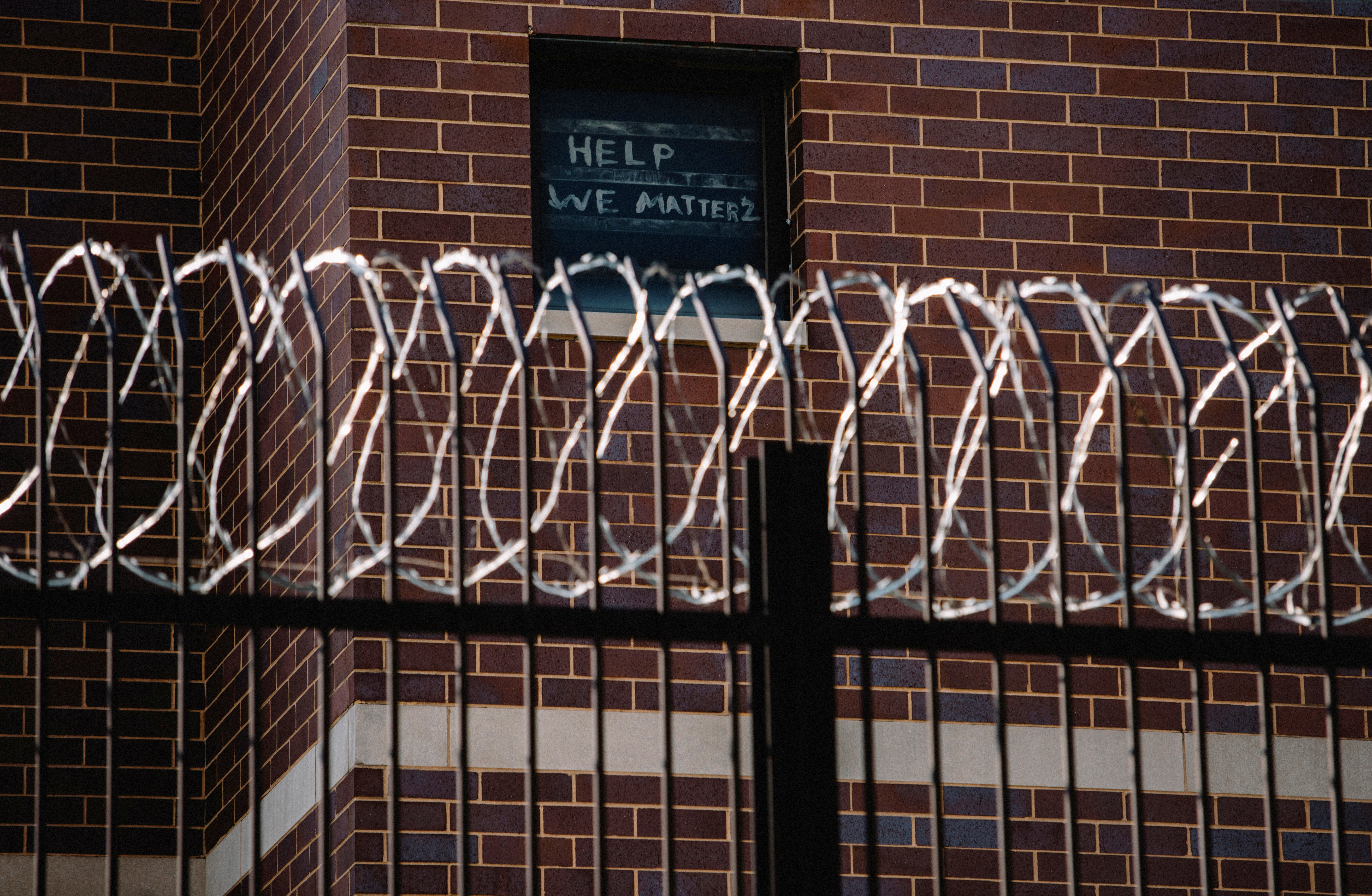 Signs made by prisoners pleading for help are seen on a window of Cook County Jail in Chicago, Illinois, US, April 7, 2020, amid the COVID-19 outbreak [File: Jim Vondruska/Reuters]
