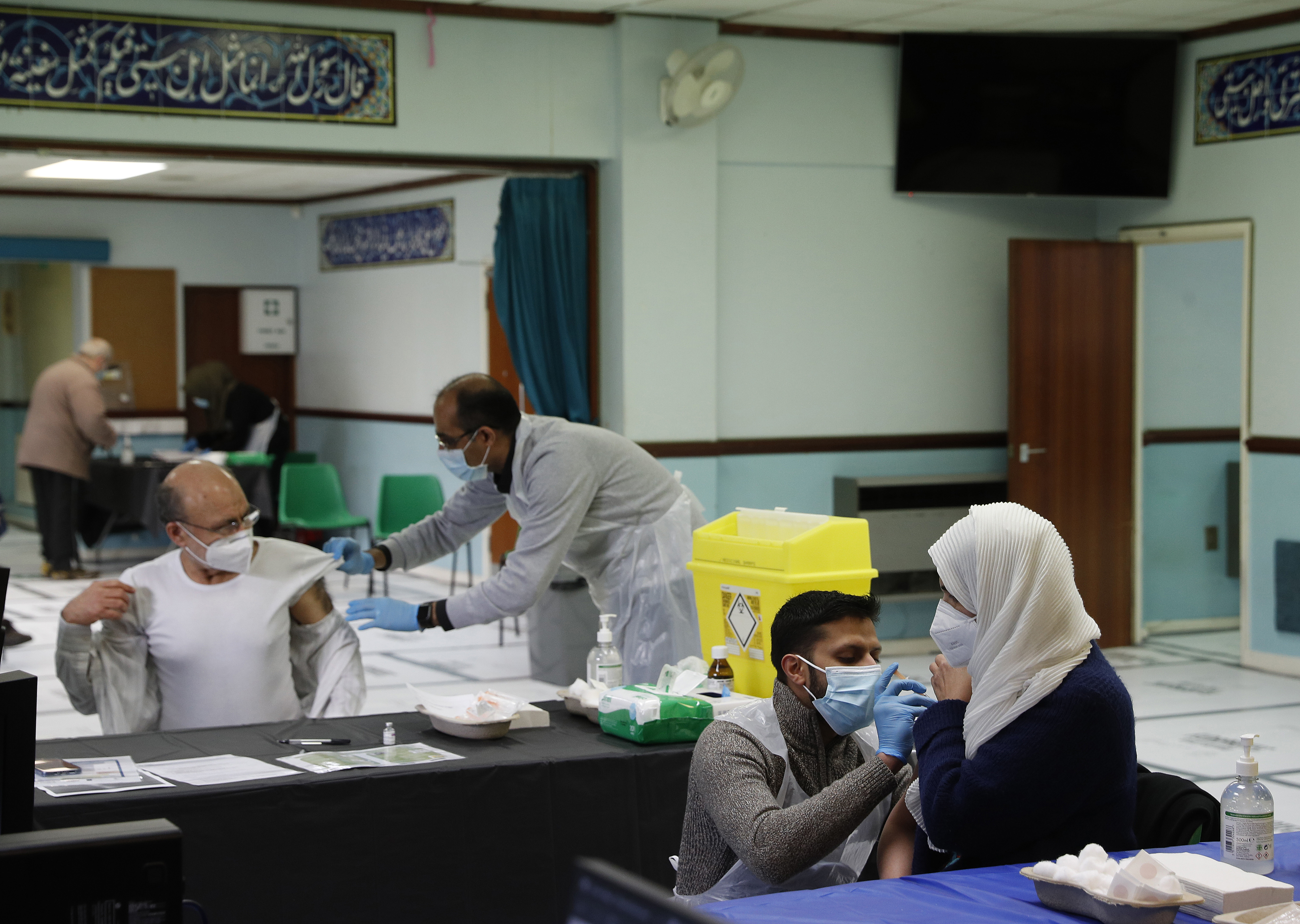 People receive the Oxford-AstraZeneca COVID vaccine at the Al-Abbas Islamic Centre, which has been converted into a temporary vaccination centre in Birmingham, central England on January 21, 2021 [Darren Staples/AFP]