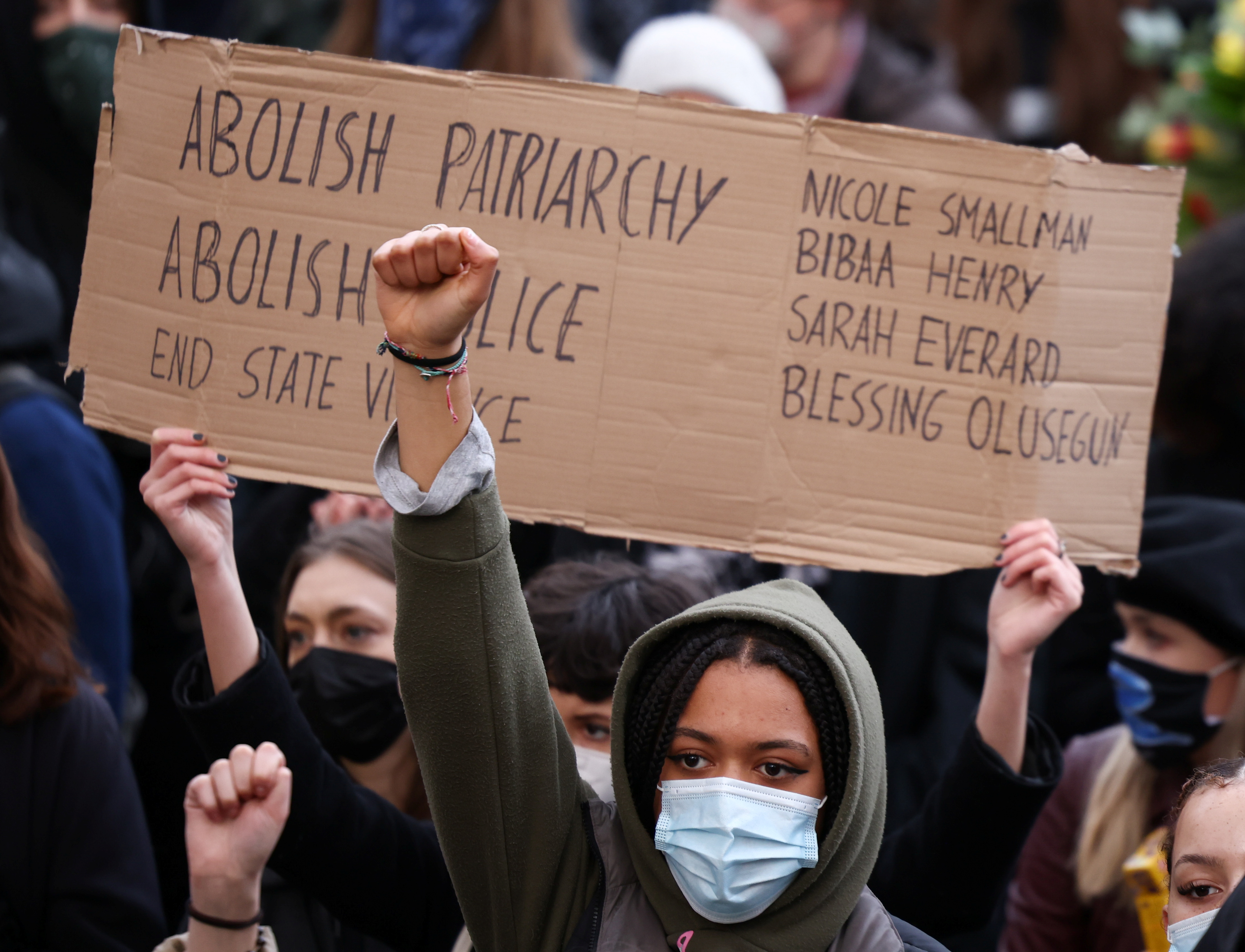 Women hold signs during a protest at Parliament Square, following the kidnap and murder of Sarah Everard, in London on March 15, 2021 [Henry Nicholls/Reuters]