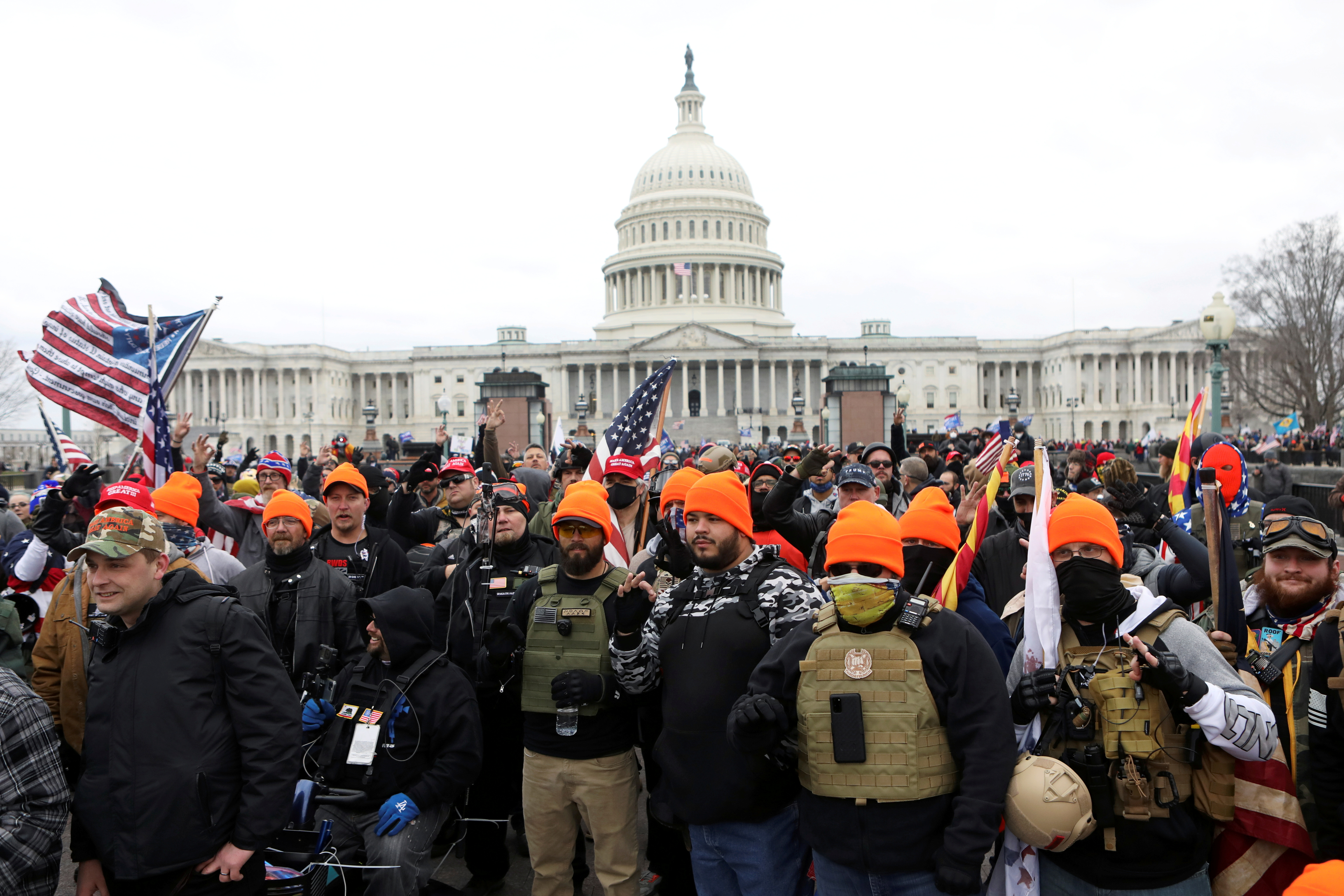 Proud Boys members flash a sign in front of the US Capitol