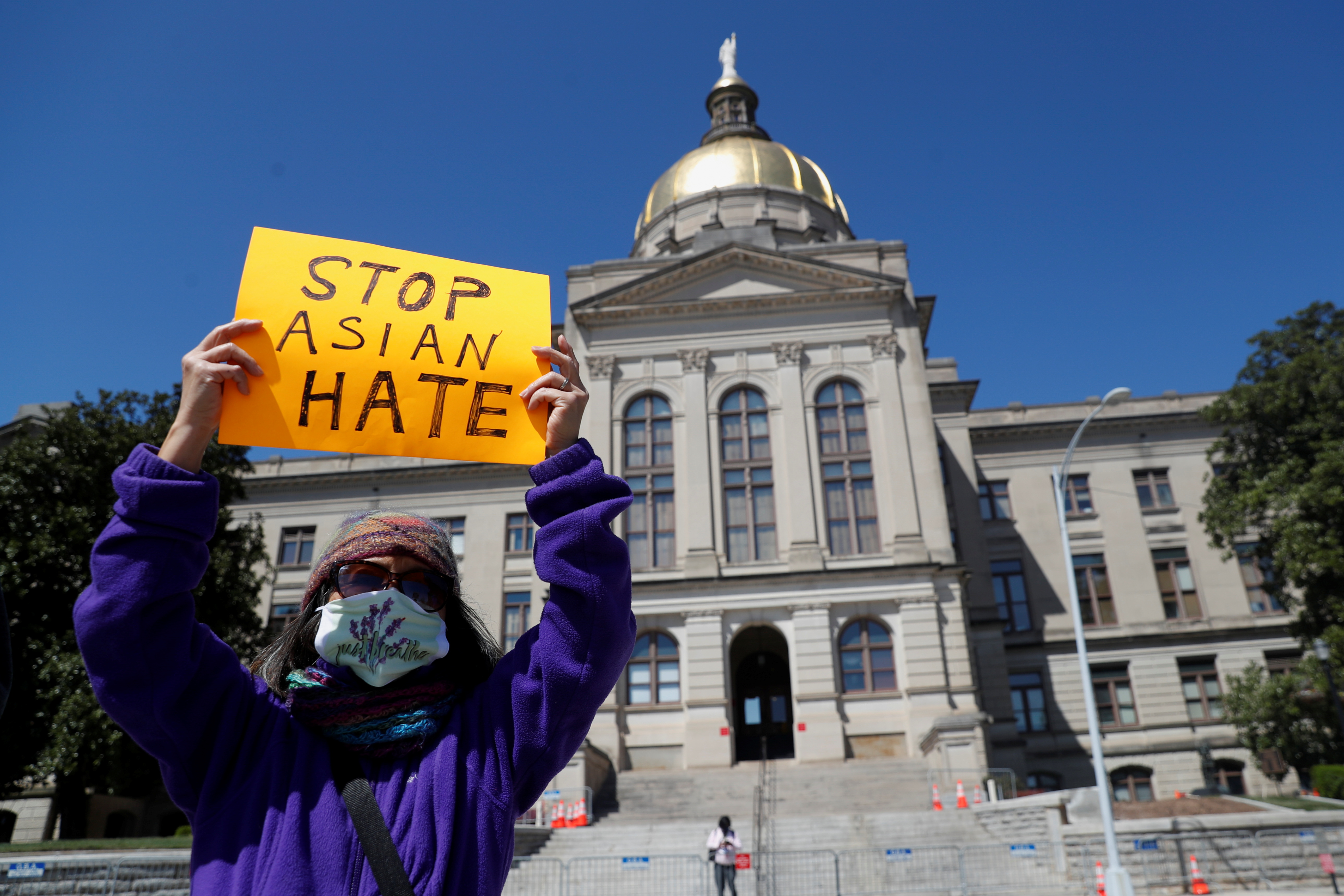 A person holds a placard during a 'Stop Asian Hate' rally, following the deadly shootings, in Atlanta, Georgia, March 20, 2021 [Shannon Stapleton/Reuters]