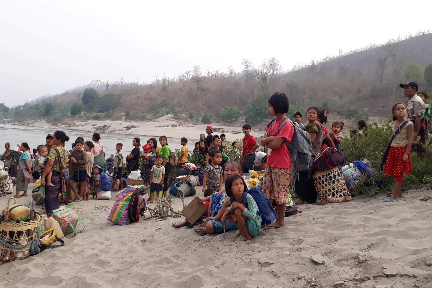 Karen refugees carrying belongings are seen at Salween riverbank in Mae Hong Son, Thailand on March 29, 2021 [Karen Women's Organization/Handout via Reuters]