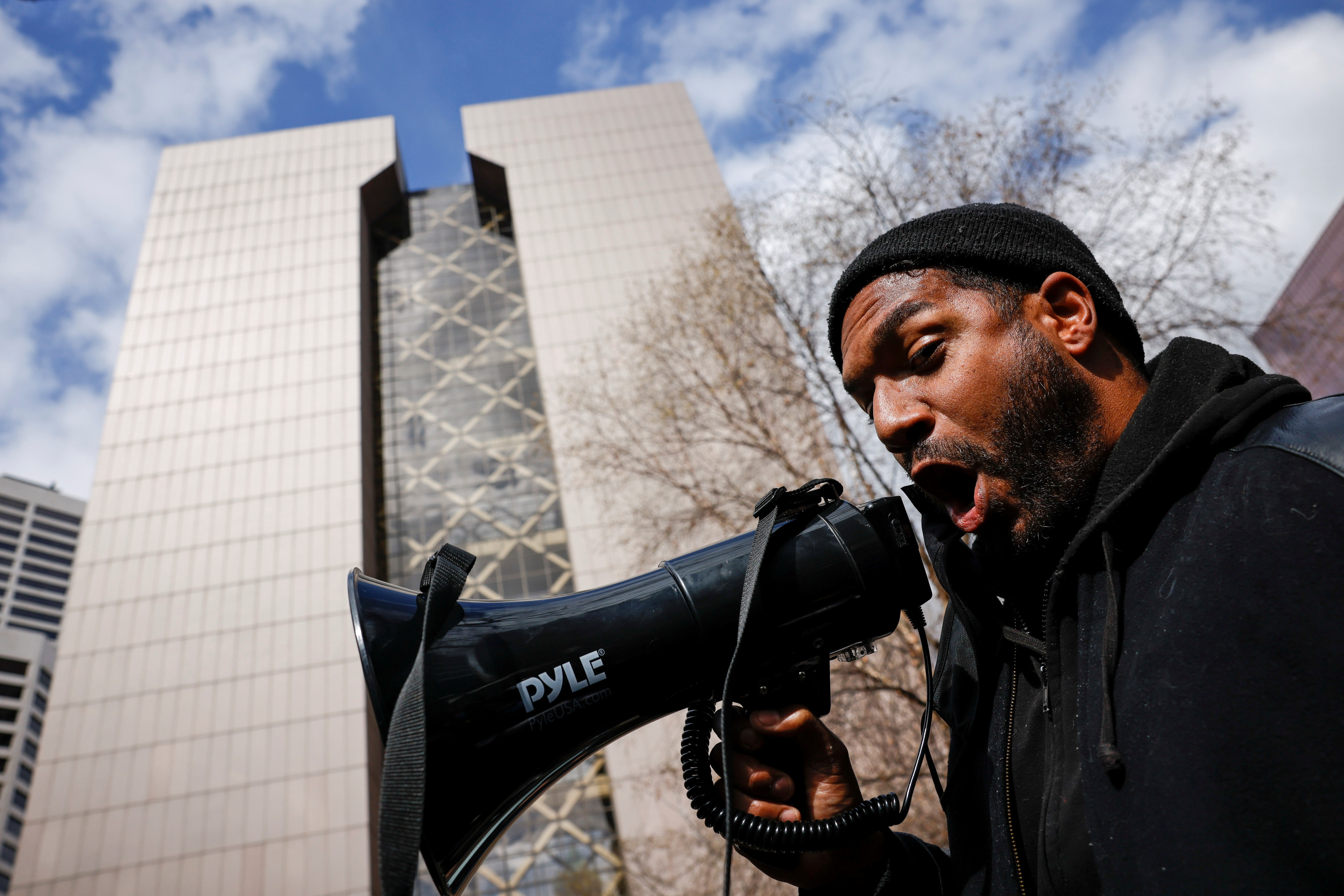 A protester shouts into a megaphone in front of the Hennepin County Government Center in Minneapolis, Minnesota on April 20, 2021 [File: Carlos Barria/Reuters]