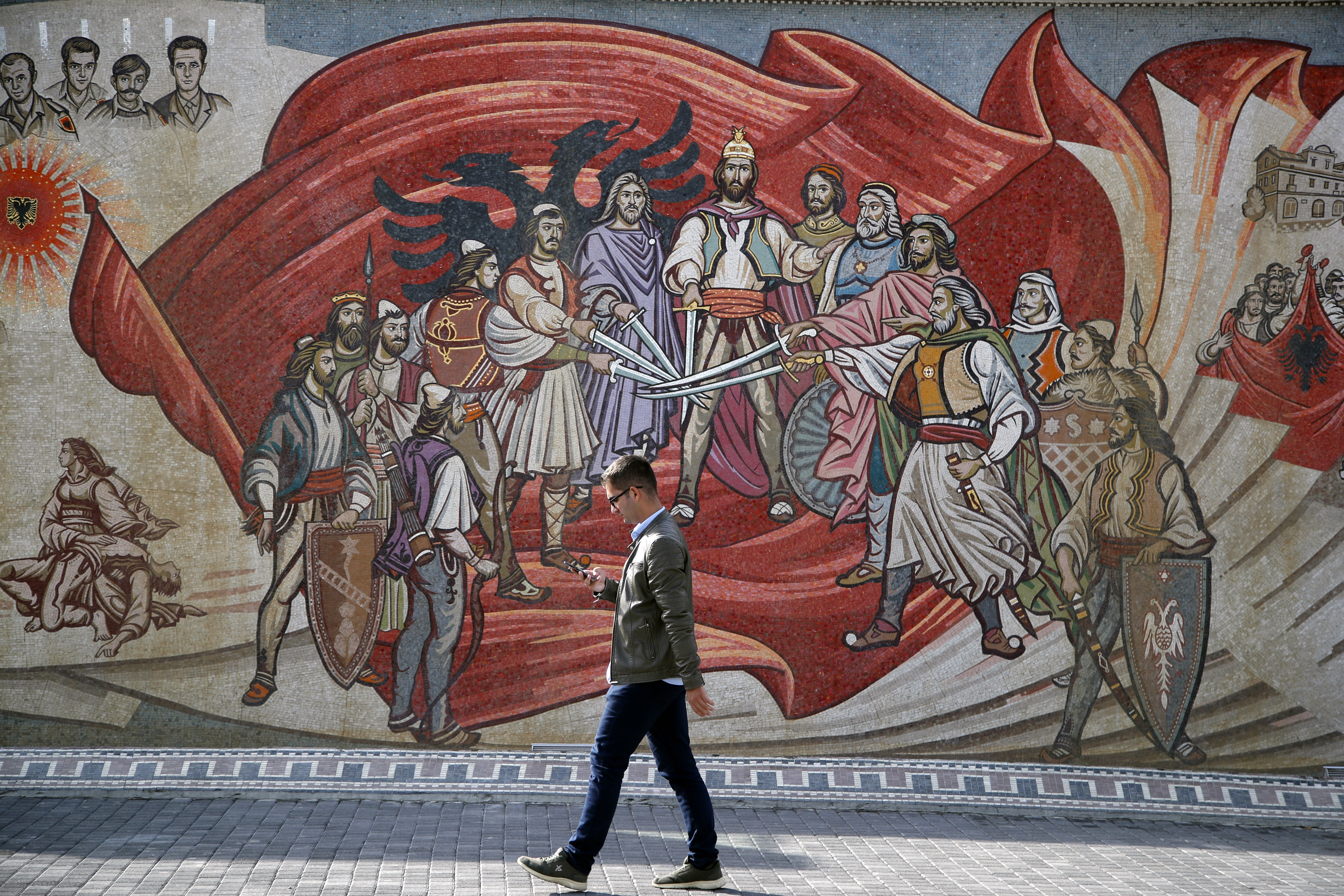 A man passes an ethnic Albanian mural in Skopje, North Macedonia, on October 1, 2018 [File:AP/Thanassis Stavrakis]