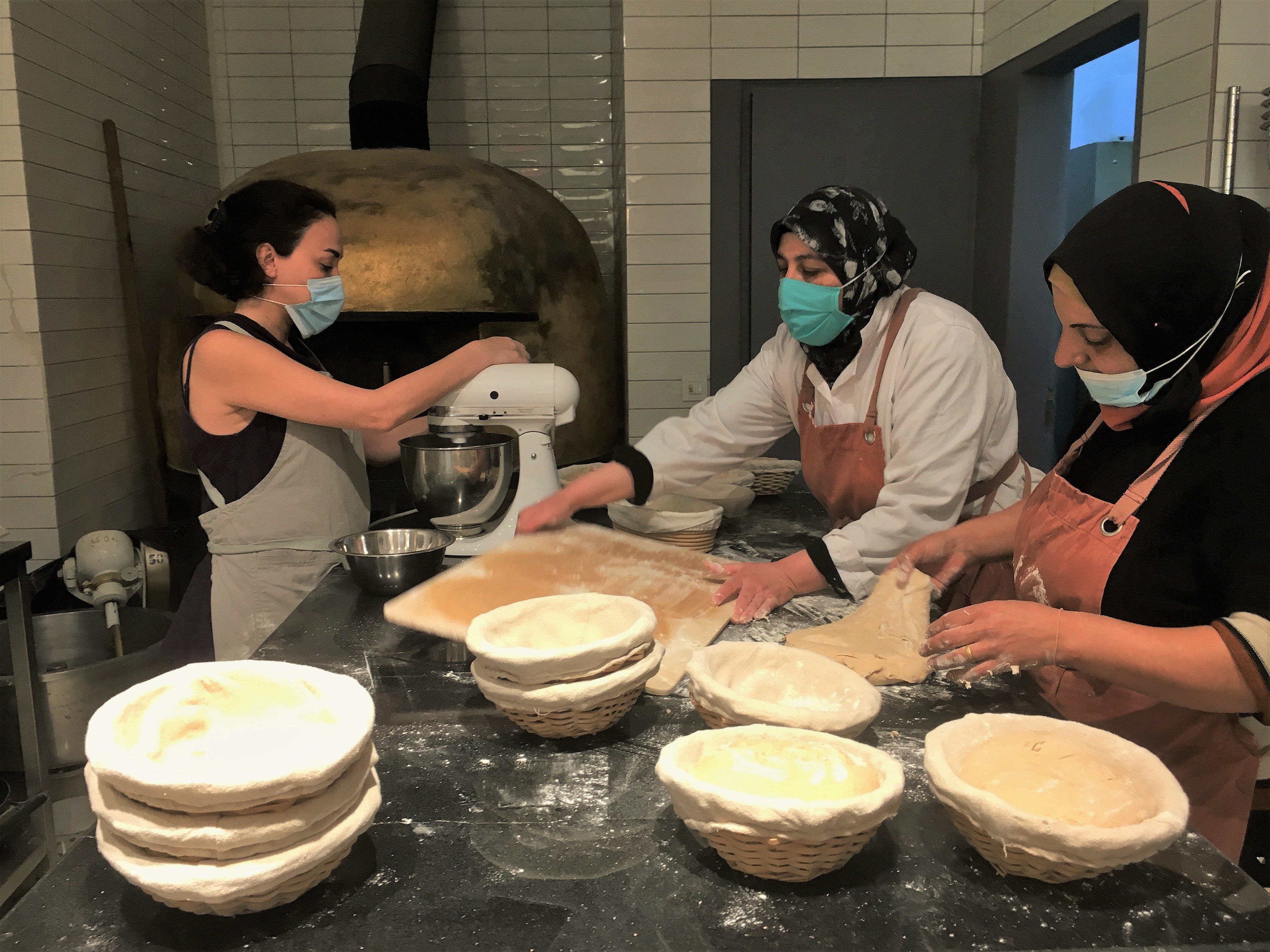 Mavia's bakers prepare dough for the next batch of bread [Maghie Ghali/Al Jazeera]