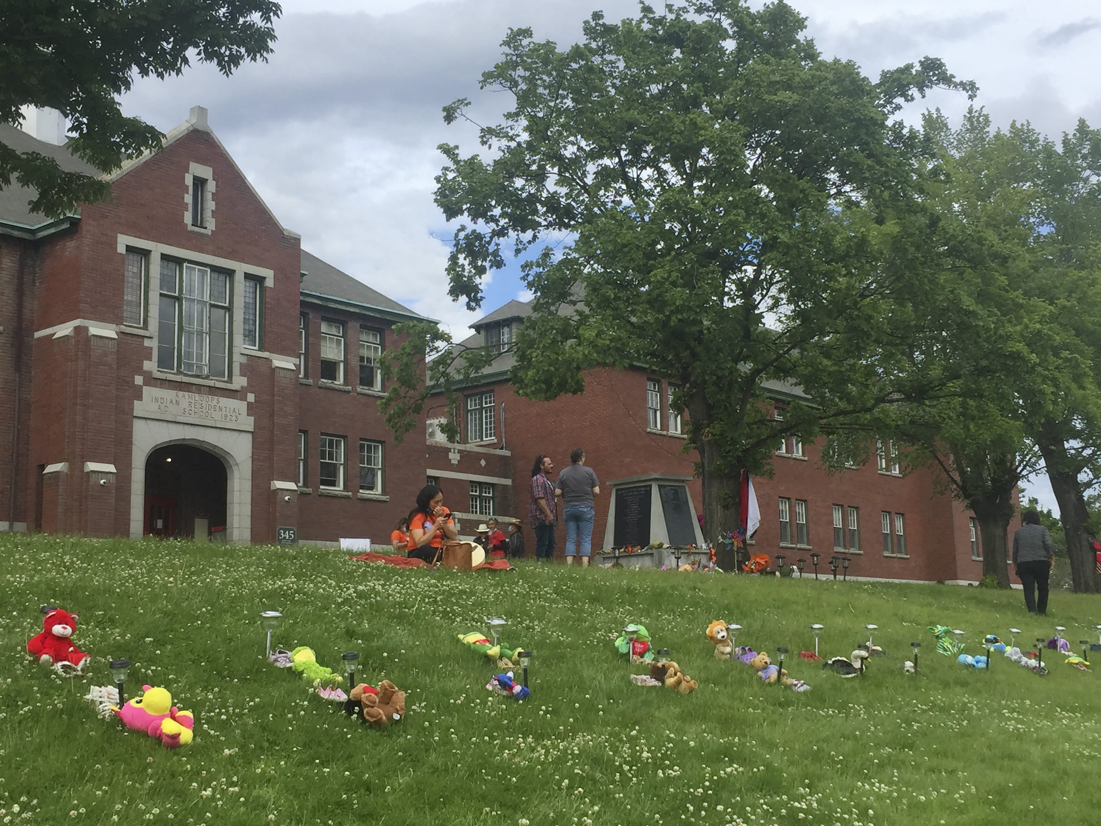 Flowers and tributes are laid out in front of Kamloops Indian Residential School