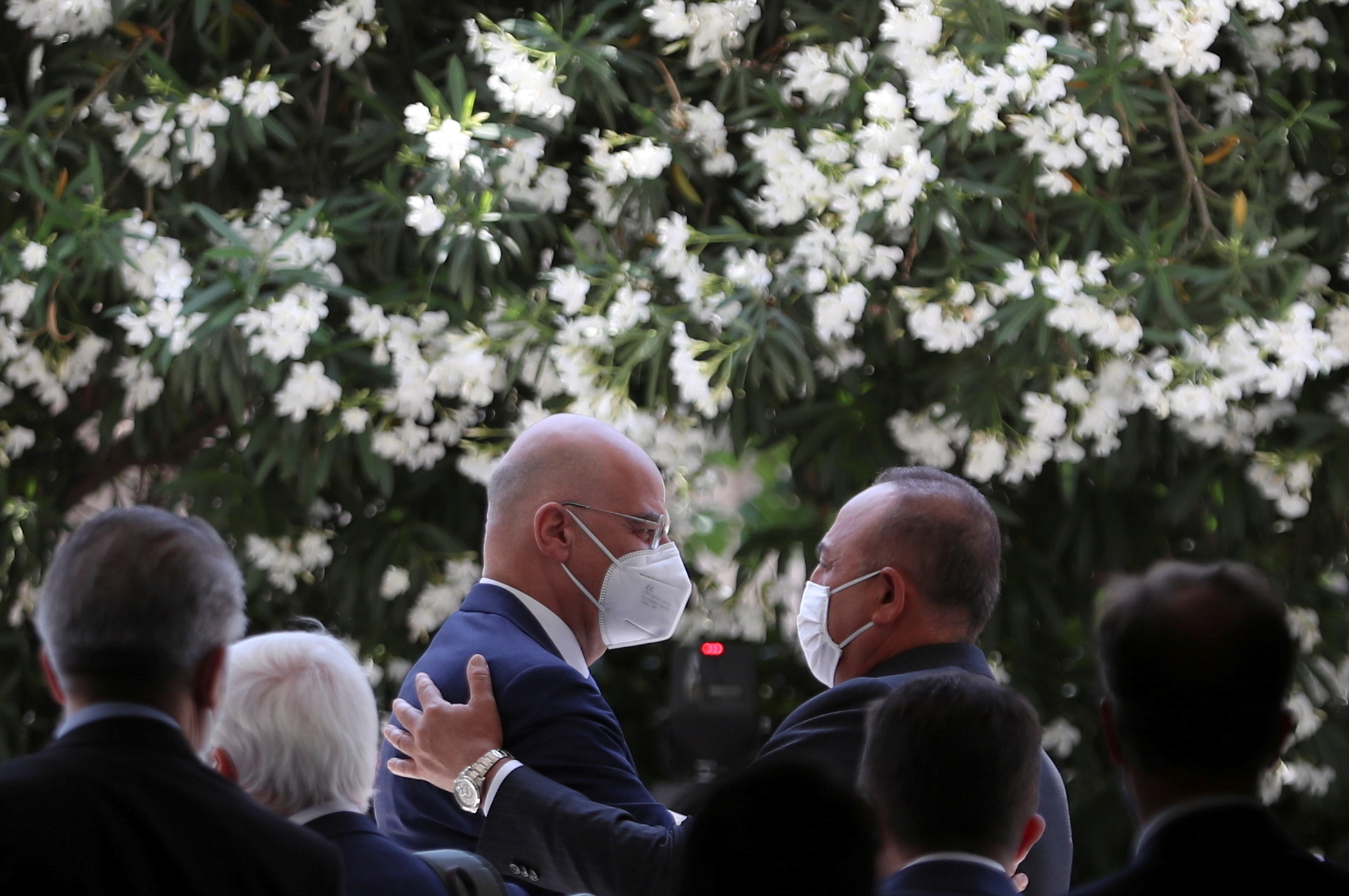 Nikos Dendias, left, and Mevlut Cavusoglu, right, greet each other after a news conference in Athens [Costas Baltas/Reuters]