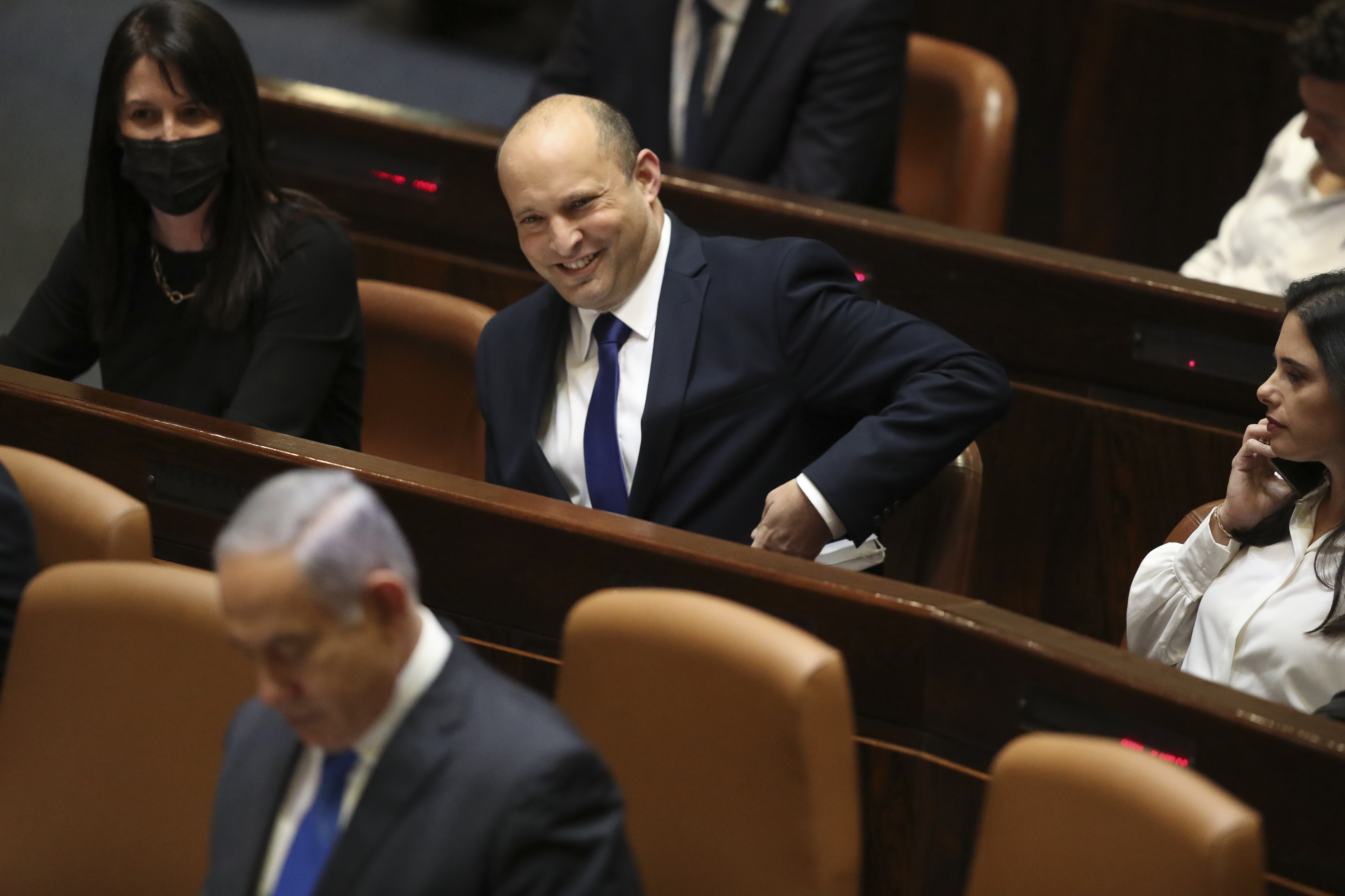 Israel's designated new prime minister Naftali Bennett sits behind outgoing Prime Minister Benjamin Netanyahu during a Knesset session in Jerusalem on June 13, 2021 [AP/Ariel Schalit]
