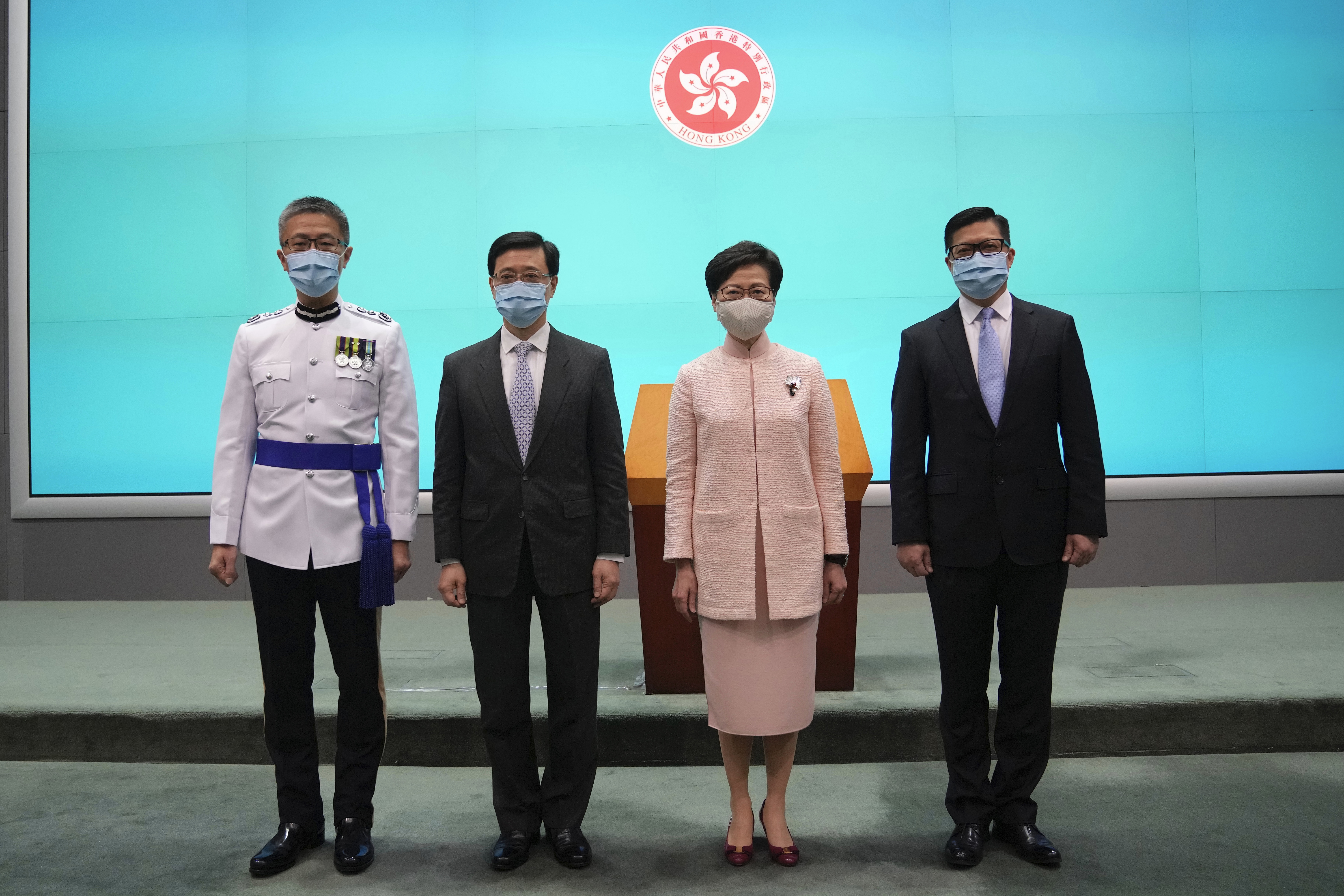 Hong Kong's Chief Executive Carrie Lam, second right, poses with Chief Secretary John Lee on the day he was promoted to No. 2 in June 2021